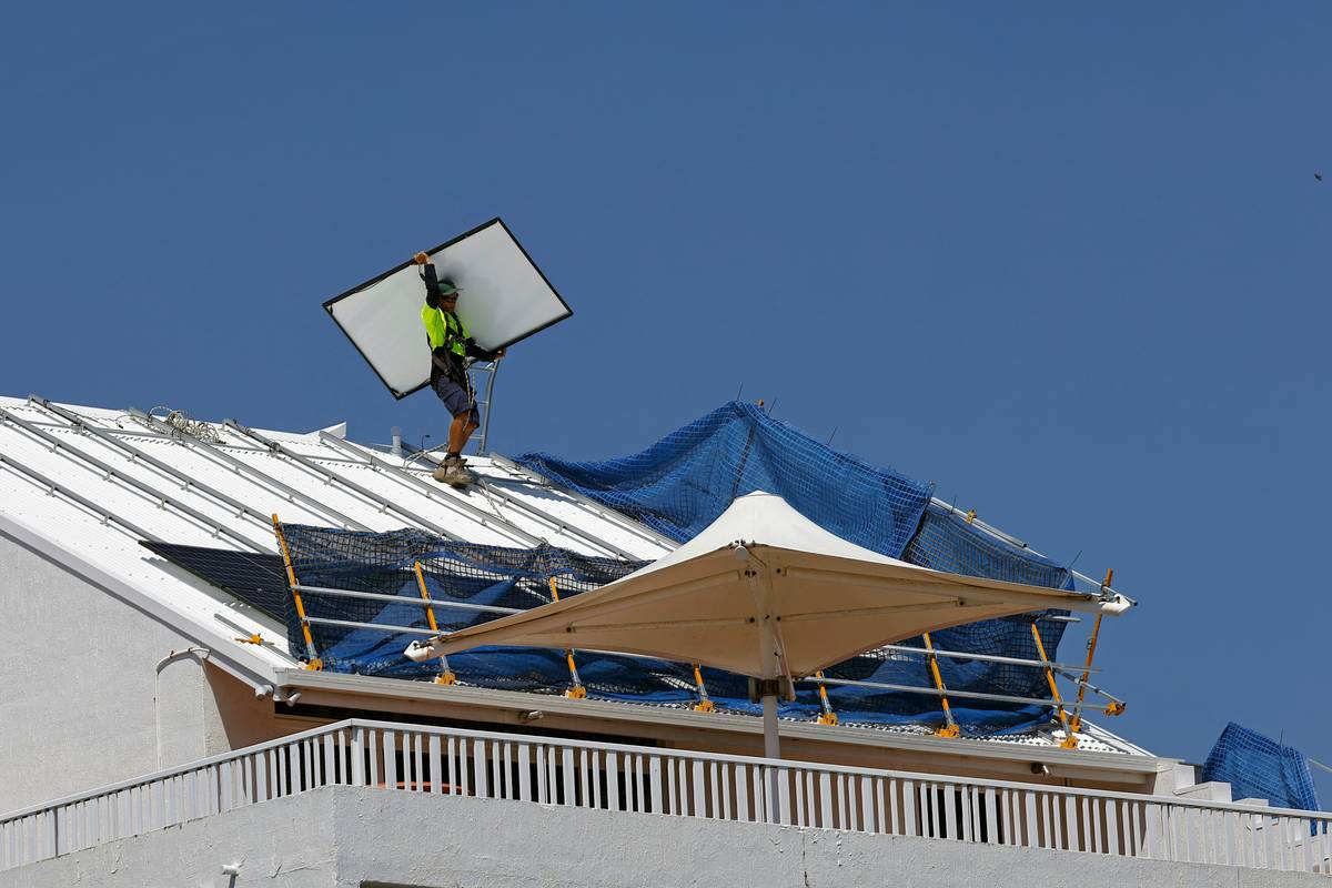 Maintenance supply panel how to de: person using soft brush and deionized water on rooftop solar array